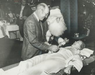 Blood is a Christmas Gift, Santa Claus gave blood at a Red Cross clinic yesterday at the Bramalea City Centre-and also joined Brampton Mayor Jim Archd(...)