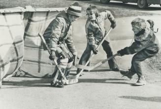 Even street hockey captures the enthusiasm of Orangeville superstar, 8-year-old Bobby Cooke (right) as he plays with chums Ron Costescu (left), 12, an(...)