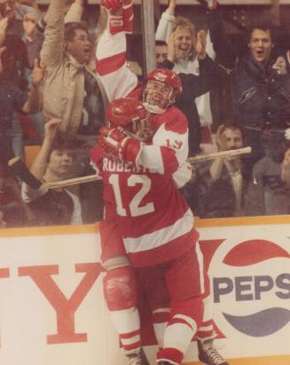 Big win: Centre Joe Nieuwendyk is hugged by teammate Gary Roberts after scoring goal that helped Canada beat the United States 5-2 in world junior hockey championship