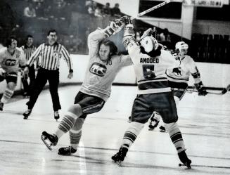 Opps! Toronto Toros' defenceman Mike Amodeo (5) spilled Rich Morris (10) of Chicago Cougars during last night's World Hockey Association semi-final ga(...)