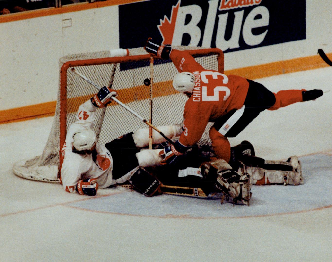 Crash! Steve Chiasson knocks Wendel Clark off his feet but Red goaltender Vincent Riendeau gets the worst of it during Team Canada's Red-White game la(...)