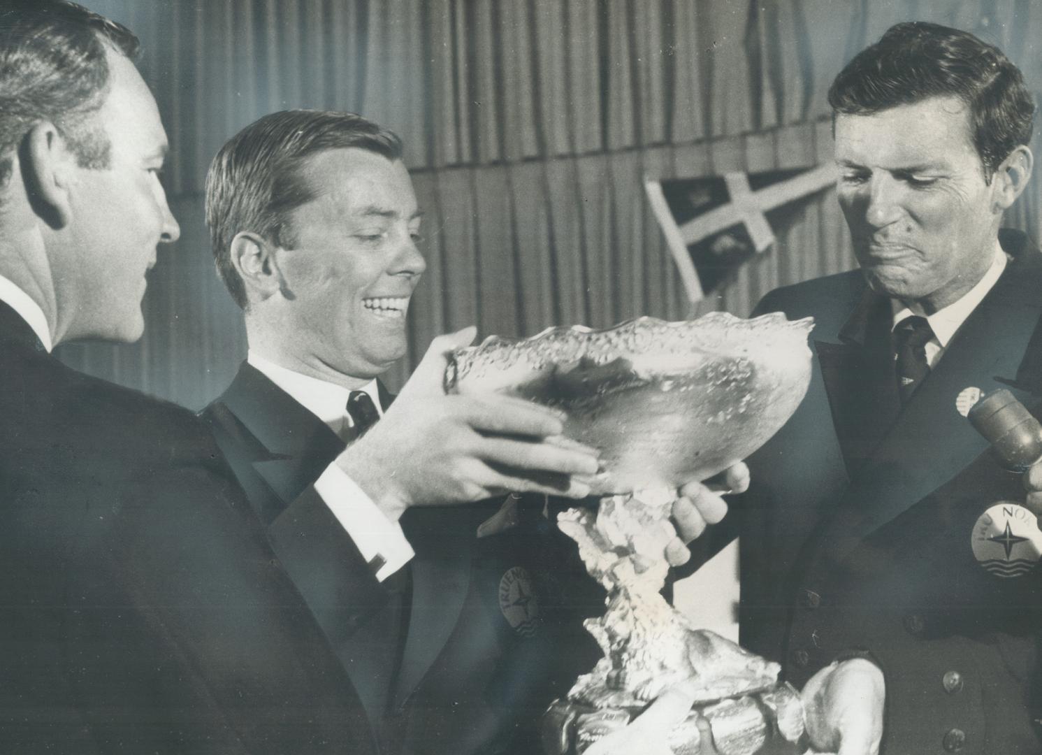 Perry Connolly taking drink from Canada's Cup during celebration at Royal Canadian Yacht Club, with Gord Fisher and Dave Osler