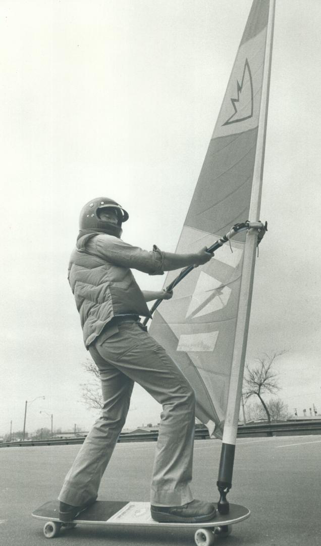Beached sailor Stan Louden skims over the parking lot at Woodbine Beach on his sailboard, complete with sail, mast and boom on a skateboard base. To b(...)