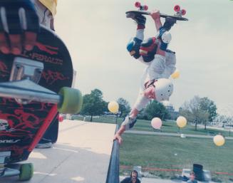 Head over heels over skateboarding, Tom Boyle stuns onlookers as he balances on one hand on the edge of a skateboard ramp in a crackerjack example of (...)