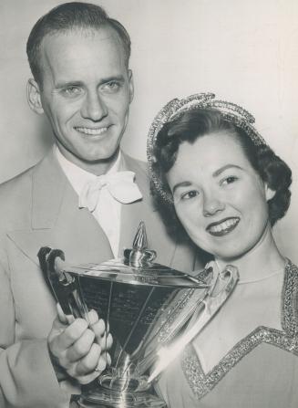The skaters [Frances Dafoe and Norris Bowden] are seen, right, holding the North American championship cup which they added to their Canadian laurels.(...)