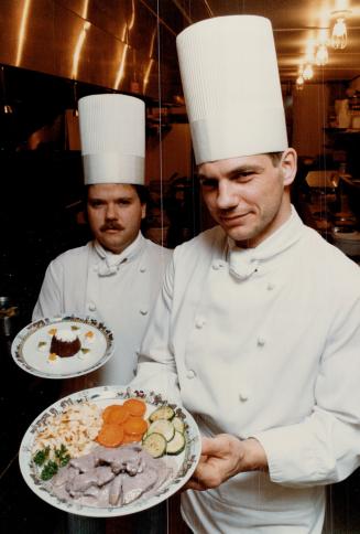 Bert Dinkel (left) and Urs Hirzel cook up Swiss dishes, including raclette, fondue and air-dried beef, at a Calgary restaurant that the Swiss Tourist Board set up especially for the Winter Games