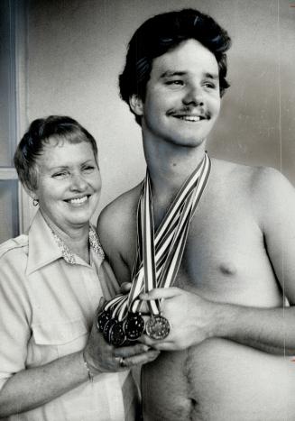 A touch of gold: Betty Rheaume of Mississauga beams with pride as 19-year-old son John Marc displays the five gold medals he won in swimming at the Ontario Special Olympics, held at York