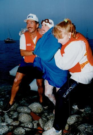 Marathon triumph. Patty Thompson, 45, is helped on to shore by husband Dave Marr last night after becoming the oldest woman to swim Lake Ontario