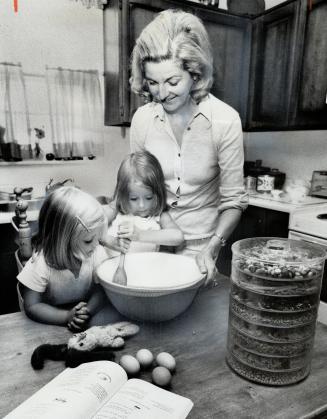 Suzanne and Sara Redman, 2 and 4, cook with their mother, Mrs