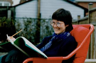 Toronto's Cathy Stinson, looking over a manuscript on her back porch, is an Annick author