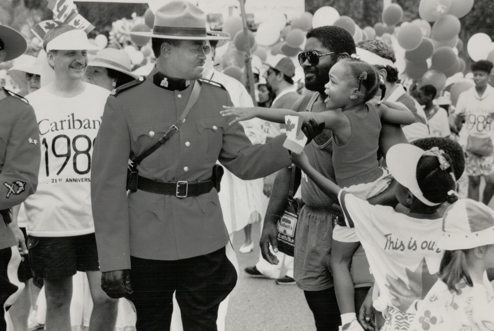 Caribana costume: Constable Curtis Hunt gets some attention from an admirer for his costume, the scarlet tunic of the RCMP, at Caribana parade yesterday