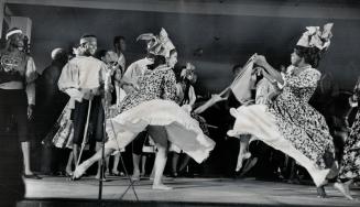 Twirling and spinning, gaily costumed dancers cavort to the pounding beat of musicians from the Trinidad and Tobago show at Expo, in Toronto as part o(...)