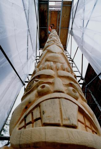 Look Wa-ay up: And you'll see Peter Janes on scaffolding carving a totem pole out of the 110-year-old white pine on his brother Steve's Pickering property