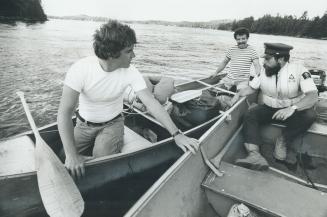 Park ranger checks out a canoe's safety equipment on Canoe Lake [Incomplete]