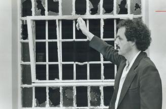 Prison official John Walker indicates the 9-by-18-inch window gap seven prisoners escaped through at Guelph