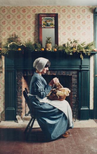 Preparing for a colonial Christmas, Brampton resident and Mississauga heritage management intern Marisa Asta-Williams knits in front of a decorated ma(...)