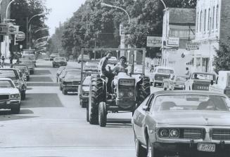 Farm tractor mingles with traffic on Mount Forest's Main Street