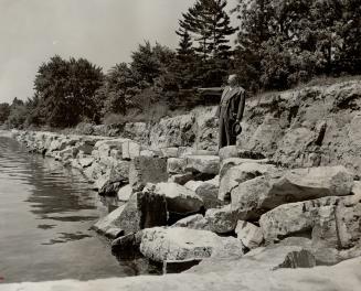 Erosion of the seawall at Oakville has been halted by this 1,010-foot-long stone embankment erected by the town and being viewed by Reeve C. V. Hillme(...)