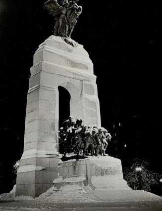 night, floodlights on the national war memorial, unveiled last summer by the King, reveal the austere beauty of snow - covered granite and bronze