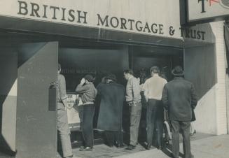 Curious spectators peer through window of British Mortgage and Trust Co