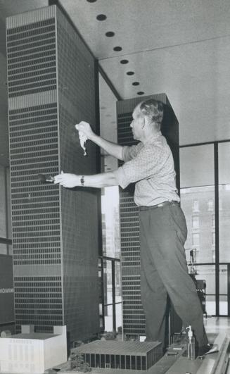A 54-storey cleaning job, Looking like a giant against the backdrop of a model of the 54-storey Toronto-Dominion Centre, John Szokald cleans the windo(...)