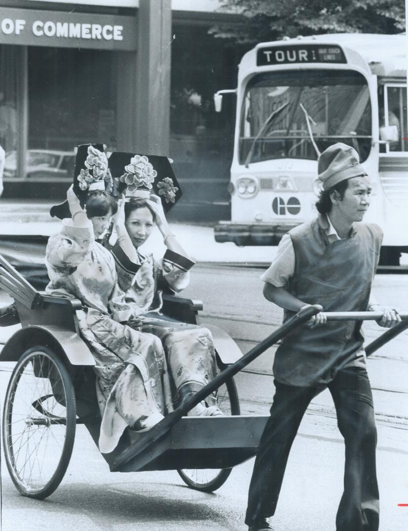 Parading in comfort, Pearl Wong and her daughter, Rita, ride in a rickshaw pulled by Gordon Lem in a parade marking the opening Saturday of China Cour(...)