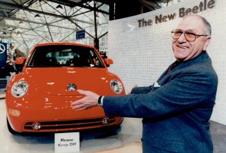 No hugging: Volkswagen dealer Peter Menzel, with new Beetle at the auto show, has sold his entire allotment even though the car doesn't arrive until mid-March