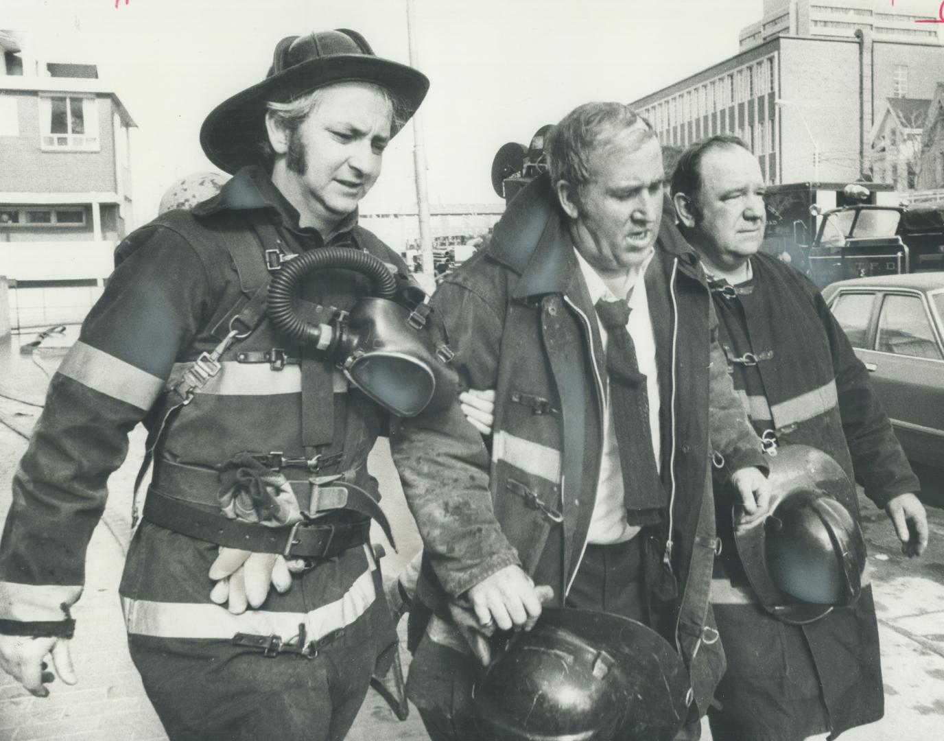 Toronto platoon Chief Jack McMurray (middle) gets help from Robert Richard (in helmet) and Bill Terrell (at right) after he was overcome by smoke figh(...)