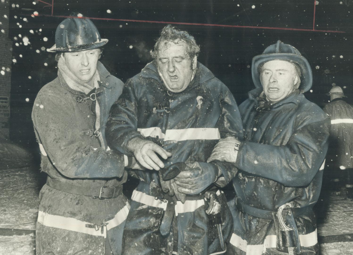 Aid to a buddy in distress, Fireman Bill Bennett of number 8 Station is helped to ambulance by firefighter Bill Cameron (left) and Trevor Harris durin(...)