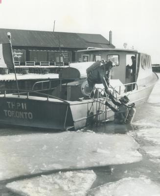 Image shows a boat and few police officers going for a swim in winter.