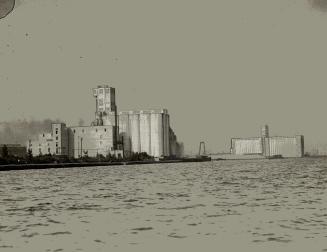 Image shows a few grain elevators by the lake.