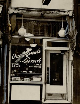 Close-up view of restaurant window and entrance. Wording on window reads: One Minute Lunch, Ste ...