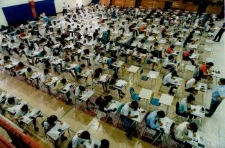 Students in gymnasium writing math exam