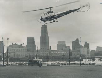 Image shows a helicopter in the air with Toronto's skyline in the background.