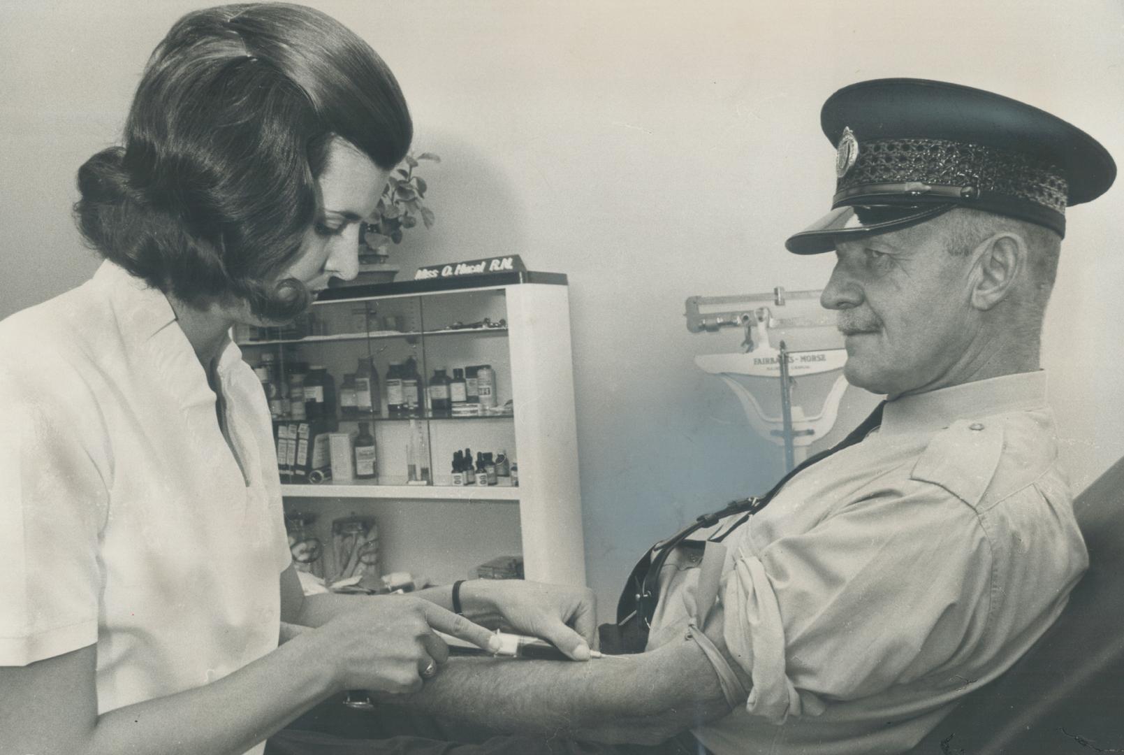 Blood test for hepattis is taken by Metro police constable John Sockett yesterday as nurse Sharon A