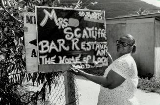 Mrs. Scatliffe adjusts the sign advertising her own special brand of home cooking