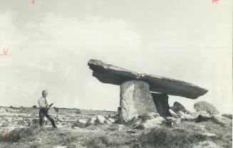 A portal dolamn or megalithic tomb dating back some 5,000 years before the birth of Christ dominates a field of stone and the strange, lunar-like land(...)