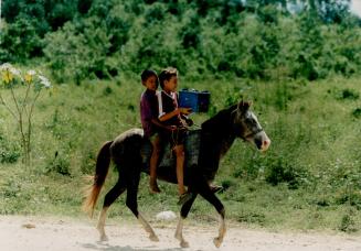 Rocking on a horse. A horse and a portable radio are all these kids need to cruise the roads near Sonaguera (close to the Canadian clinic)