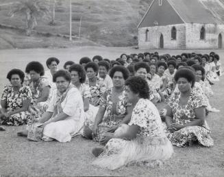 Dressed in their Sunday best, these Fiji women are shown awaiting the arrival of their Queen