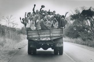 Mass transit in rural Zambia, an aged truck overflowing with a load of enthusiastic soccer fans heads off to a game between a local team and one from Lusaka, the capital