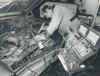 Emil Kusmann, Ed Stubbs Shell service, one of Star's two-man mechanical team, checks timing on Star's car before sending it out for test