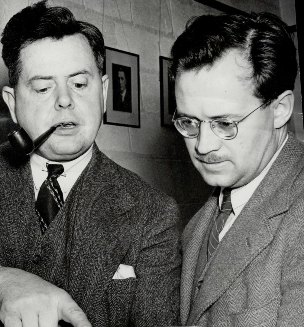 Ernest MacMillan, conductor of the Toronto Symphony Orchestra, and Charles Peaker, conductor of the huge choir, examine the score of a number