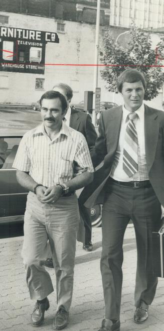 President of truckers' group - named in a conspiracy charge to extort money from independent truckers - Angelo Natale (left) of Toronto is led in hand(...)
