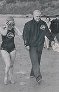 Greased up, Marilyn is pictured walking down the beach at Cap Gris Nez with coach Gus Ryder
