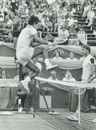 Victory leap. Jeff Borowiak's high-jumping is almost as good as tennis as he clears the net to shake hands with John Alexander whom he defeated in yes(...)