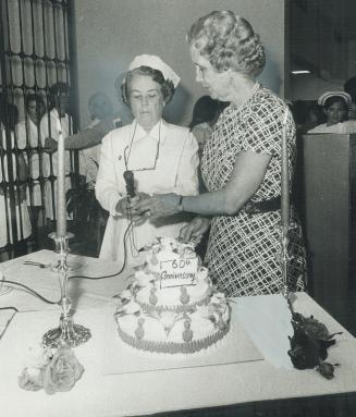 Mrs. Herbert A. Bruce, widow of the founder of Wellesley Hospital, prepares to cut its birthday cake with Dorothy Arnot of hospital