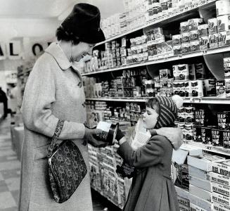 Shopping with Charlotte, Mrs. Carr finds canned meat sometimes cheaper