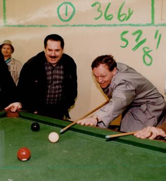 Chretien takes aim. Liberal leadership candidates Jean Chretien lines up a shot during a visit to a billiard hall on College St. yesterday. The former(...)