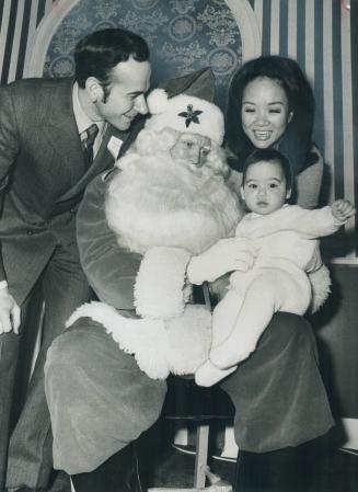 Stephen Clarkson visits Santa Claus at Eaton's department store downtown with his wife Adrienne and daughter Kyra, 6 months. He's hoping to get an ear(...)