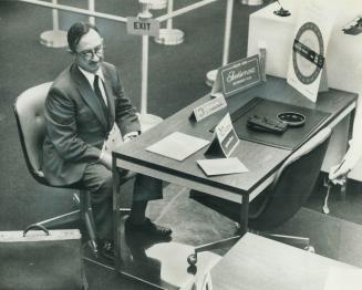 While 30 stranded vacationers wait outside, travel agent Colin Cripps sits, dejected, in the Bank of Nova Scotia